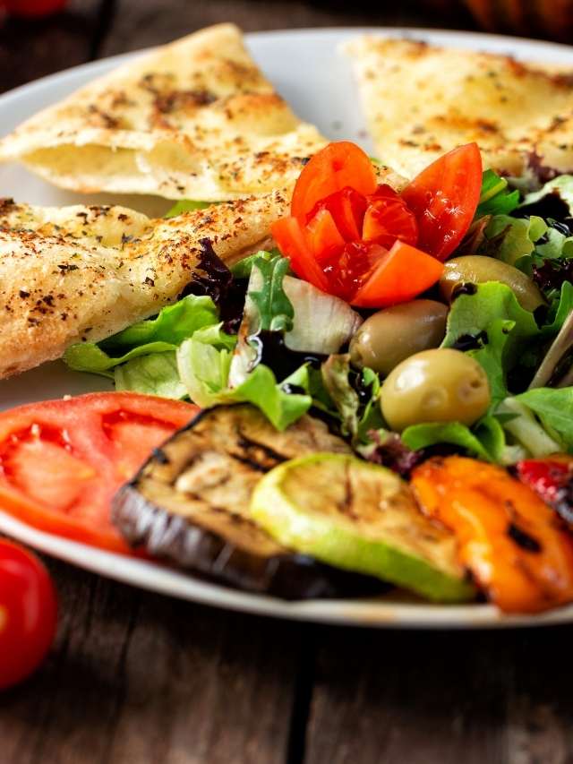 A plate with a salad and vegetables on it.